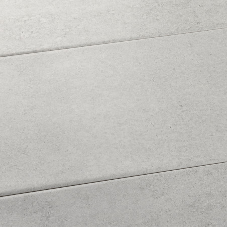 Le carrelage rectangulaire gris est plat, affichant une texture subtile et mouchetée. Il s’inscrit dans un agencement de surface