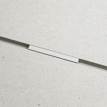 Un carreau rectangulaire lisse et beige clair avec une texture subtile présente une fine bande métallique horizontale au milieu,