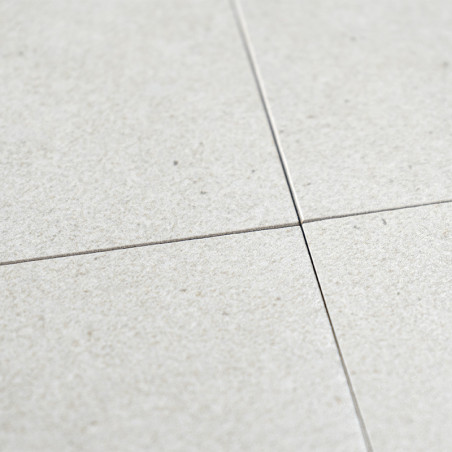 Quatro ladrilhos cerâmicos cinza claro se cruzam nos cantos, formando um padrão cruzado. A superfície tem um acabamento sutil e 