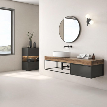 Un miroir rond est suspendu au-dessus d’un lavabo moderne sur une vanité en bois dans une salle de bains minimaliste aux murs be