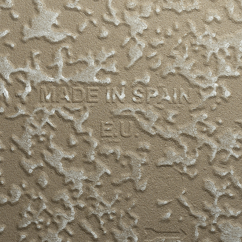Tegel met ruwe beige reliëflaag; in het midden ingegraveerde tekst: MADE IN SPAIN, daaronder E10.