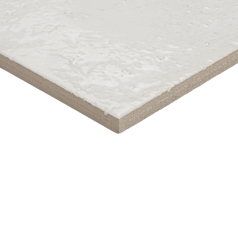 Azulejo blanco esmaltado, canto visto de cerámica con base marrón claro; fondo neutro blanco que lo aísla.