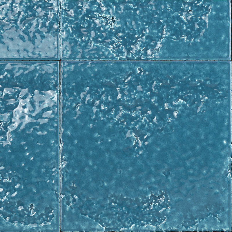 Blau glasiertes quadratisches Fliesenmuster: glänzende, unregelmäßig strukturierte Oberfläche mit sichtbaren Reflexen und schmalen, dunklen Fugen; nebeneinander verlegte Kacheln.