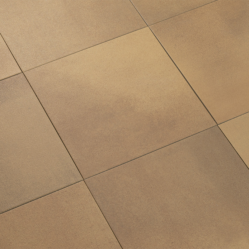 Carrelage de grands carreaux beige-brun légèrement texturés; joints fins plus foncés formant un motif géométrique régulier, sol plat sans éléments supplémentaires visibles.