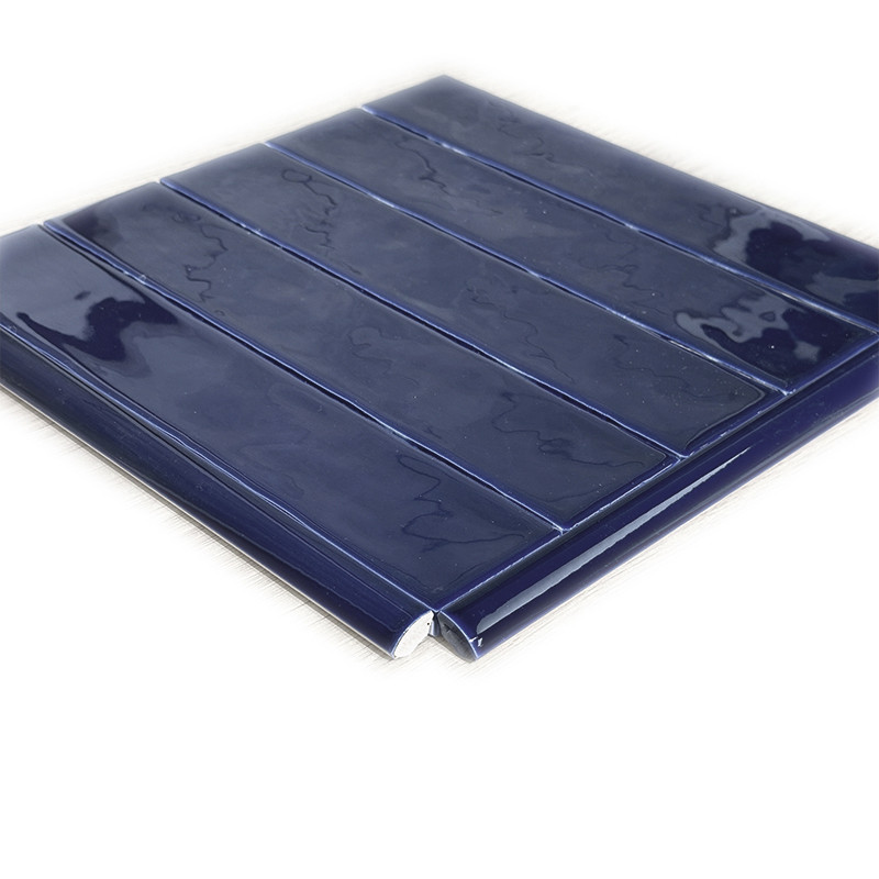 Bright blue rectangular tile with five longitudinal bands in relief; beveled edge, visible corner, on a white background, glazed surface with reflections.