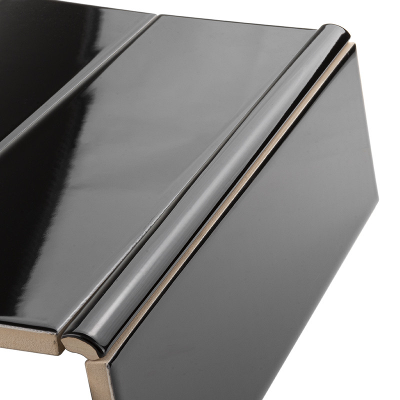 Glänzende schwarz-lackierte Keramikfliese mit abgerundeter Vorderkante (Bullnose), sichtbarer Querschnittskante; zwei Platten überlappend auf weißem Hintergrund.