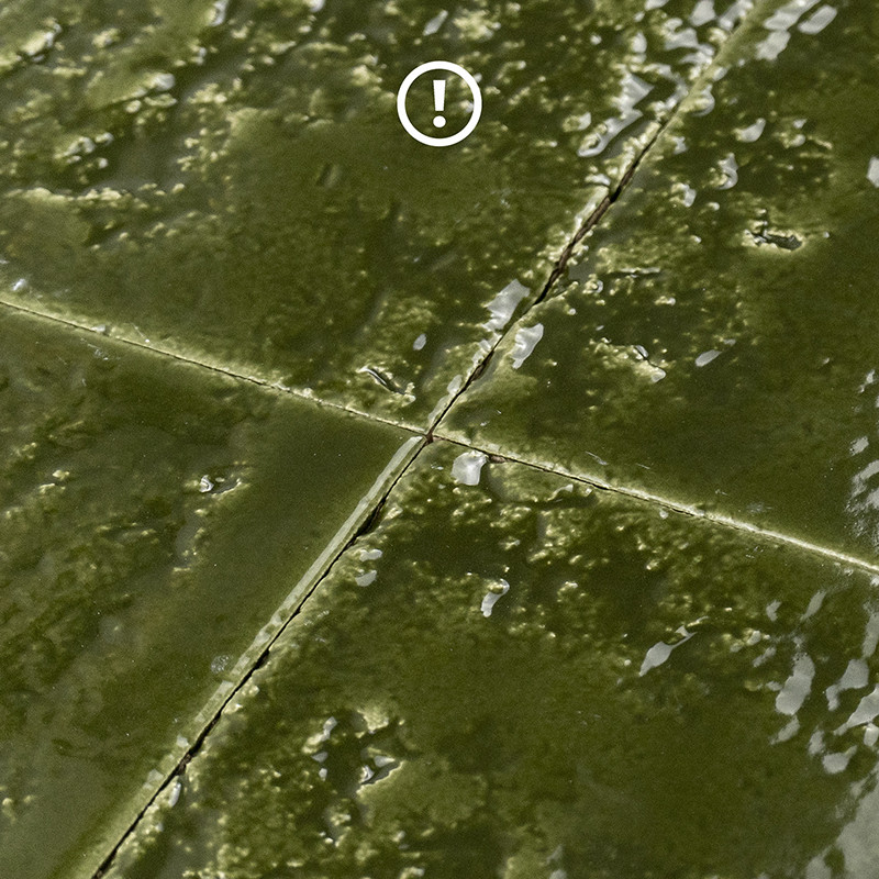 Green glazed tile with cracked surface; cross joints with indentations, irregular shine and enamel residue from wear.