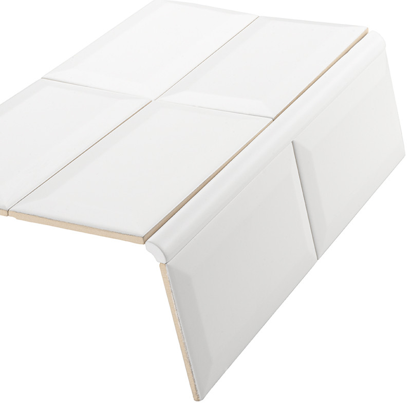 Glossy white ceramic tile with curved edge, set of four pieces arranged at an angle showing joints and edges, resting on a neutral white background.