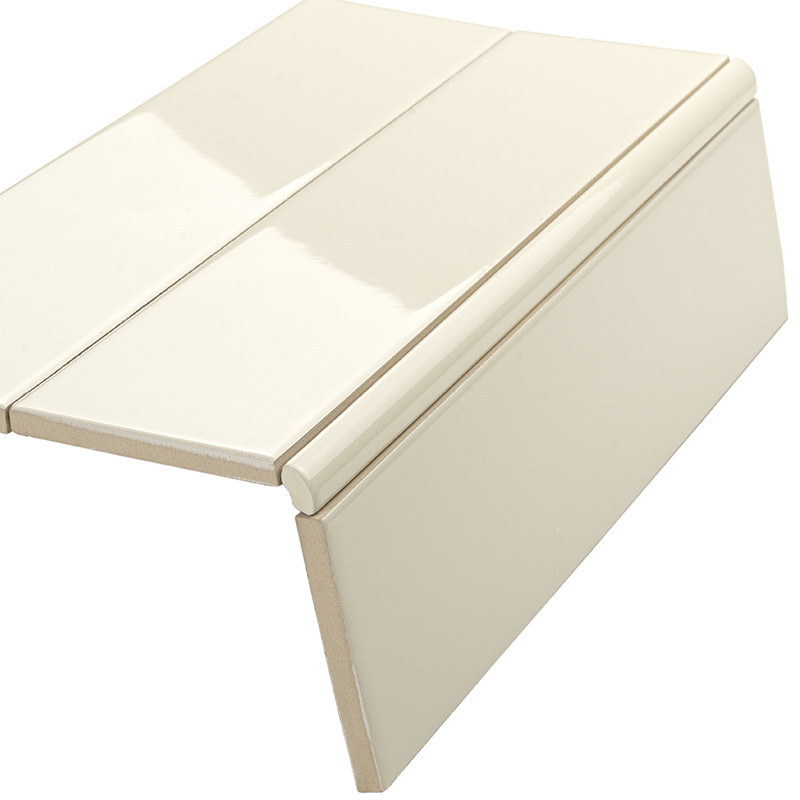 Beige glänzende Keramik-Bullnosefliese (Abschluss/Trittstufe), zweiteilig mit abgerundeter Vorderkante; freigestellt vor neutralem weißem Hintergrund, Studioaufnahme.