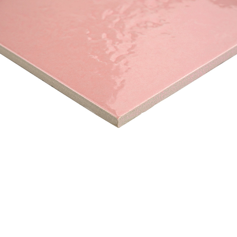 Carreau rectangulaire rose brillant, vu en léger angle; bord découpé révèle l'épaisseur et le verso beige, posé sur fond blanc uni.