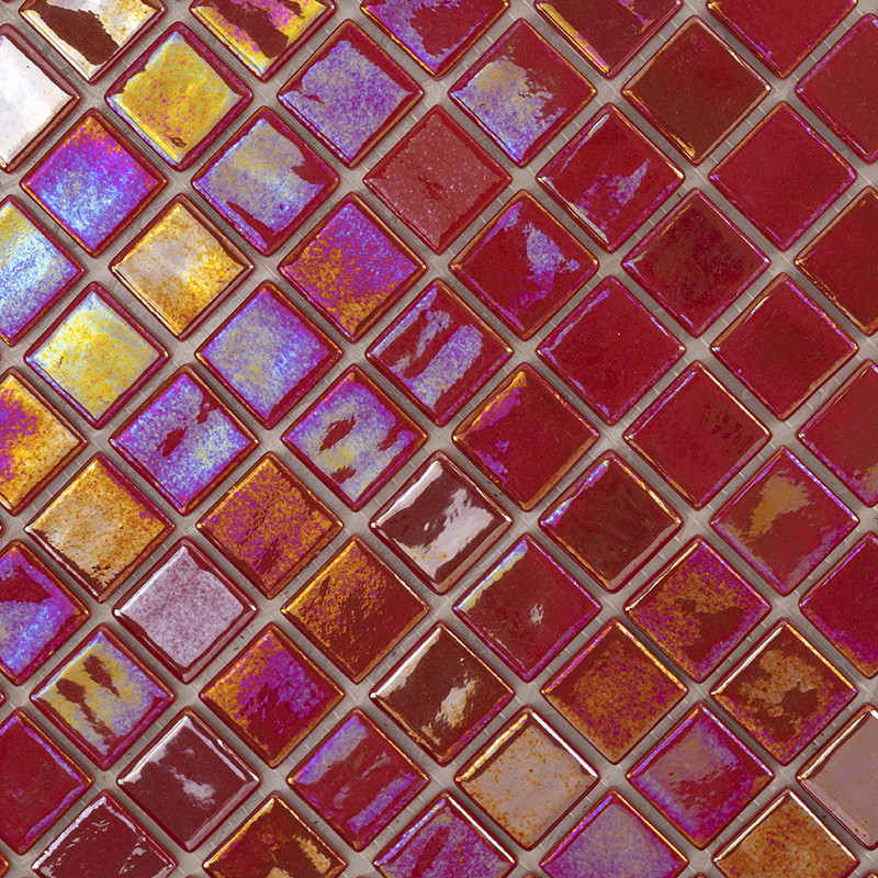 Azulejos quadrados iridescentes vermelhos, roxos e dourados, superfície brilhante, dispostos em padrão diagonal formando um mosaico compacto com rejunte claro entre as peças.