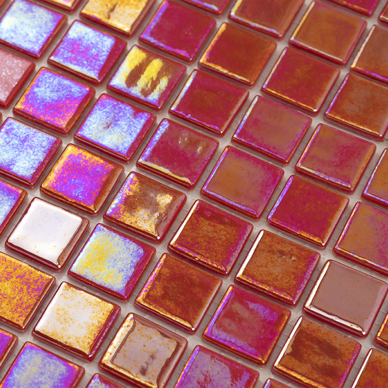 Kleine quadratische Mosaikfliesen aus Glas, rötlich-orange mit irisierenden violett-blauen Reflexen, dicht nebeneinander verlegt; glänzende, reflektierende Oberflächen und leicht unterschiedliche Farbnuancen.