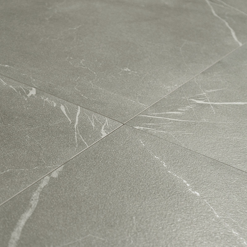 Matte gray tile with fine white veins, four pieces joined by joints that converge in the center; slightly rough surface and stone appearance.