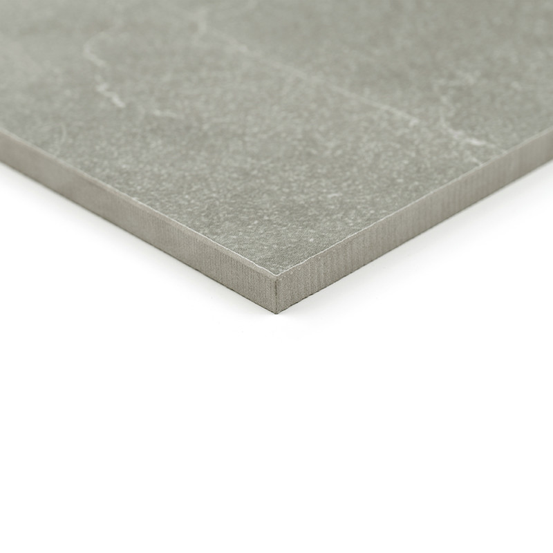 Carrelage gris aspect pierre (coin) à surface légèrement veinée, bord droit et épaisseur fine, posé sur fond blanc neutre — plan rapproché montrant texture et arêtes nettes.