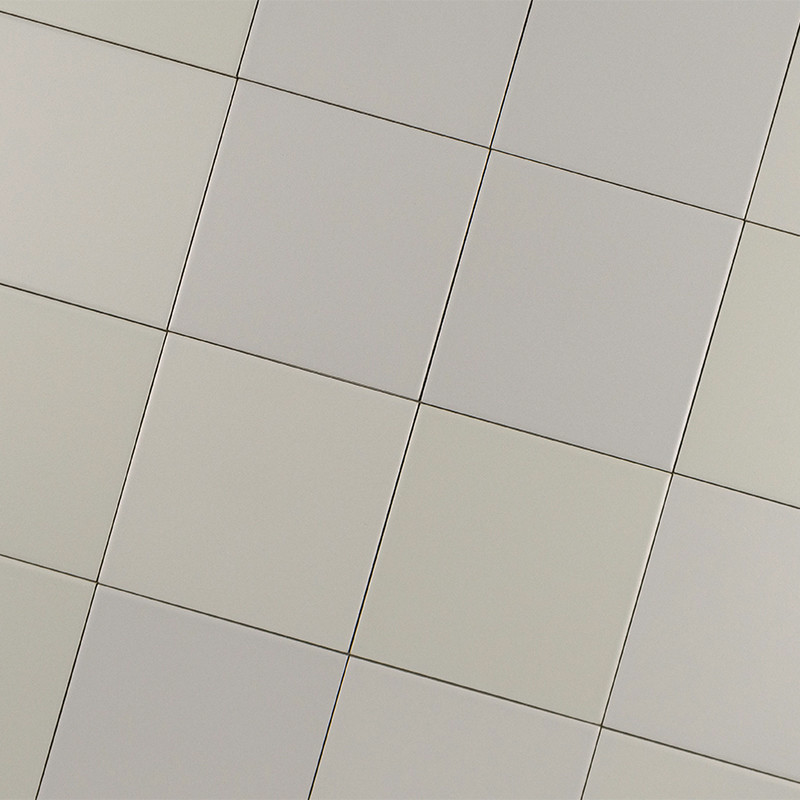 Azulejos cuadrados claros dispuestos en diagonal, juntas finas y uniformes; tonos gris y beige suaves con variaciones sutiles, superficie lisa y acabado mate.