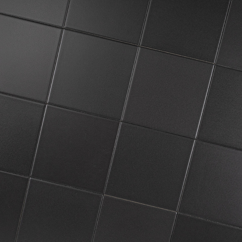 Mattschwarze quadratische Fliesen; regelmäßiges Fugenraster, diagonale Perspektive, dezente Lichtreflexe und Schattierungen, gleichmäßig angeordnet.