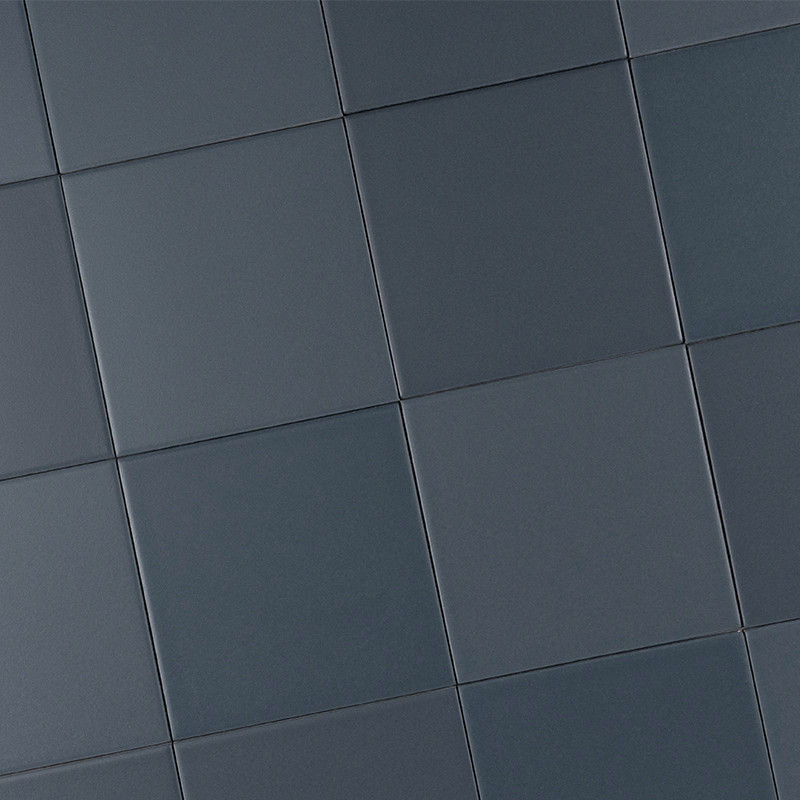 Azulejos cuadrados lisos color gris azulado; patrón en cuadrícula diagonal con juntas finas, acabado mate y sutiles variaciones tonales que crean un efecto geométrico regular.