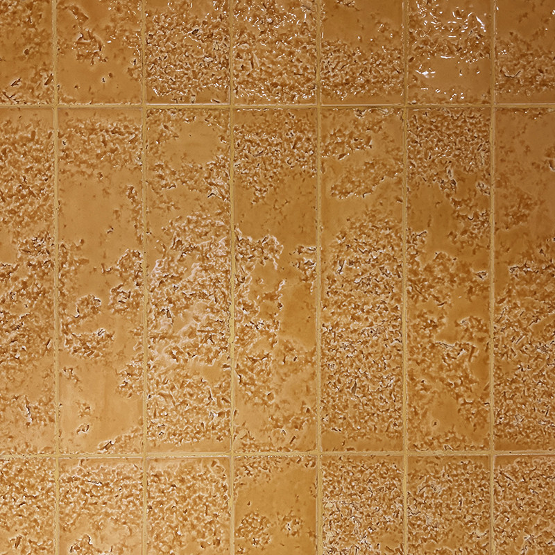 Carrelage texturé beige-orangé: carreaux carrés en grille couvrant toute la surface, surfaces irrégulières avec reliefs granuleux et joints fins réguliers.