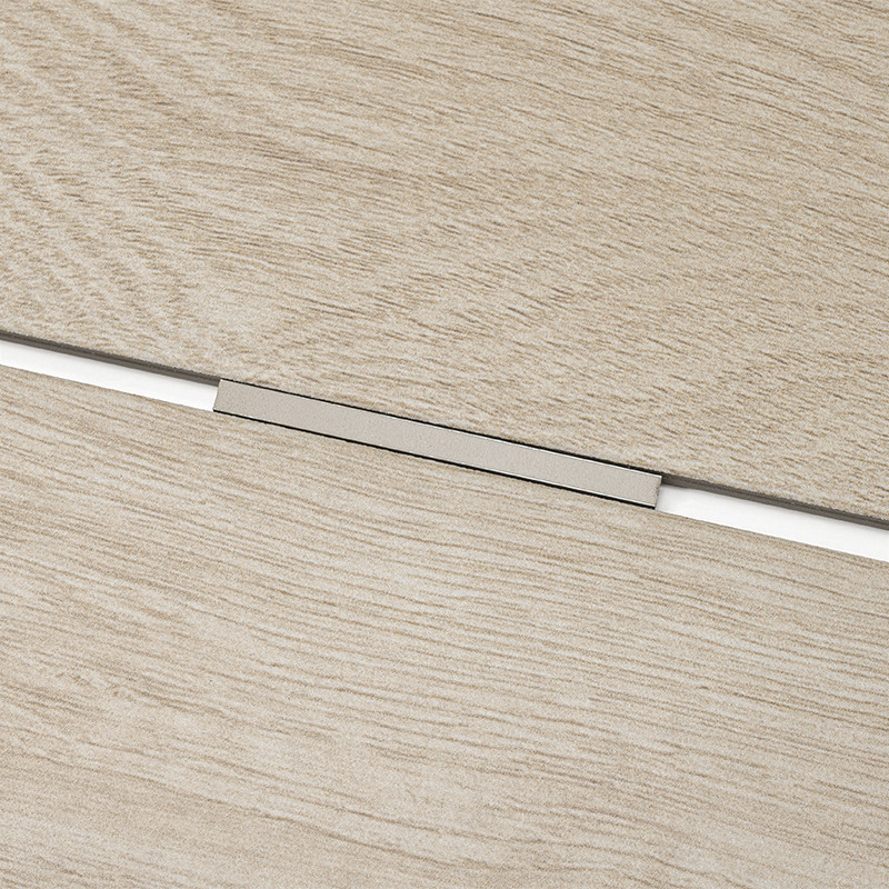 Carrelage imitation bois clair, deux dalles séparées par un joint horizontal contenant un profilé métallique argenté encastré; joint blanc visible dans l'interstice.