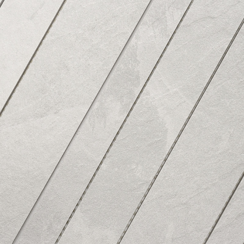 Light tile with stone texture and veining; grooved diagonal lines forming strips separated by thin joints, grayish matte surface.