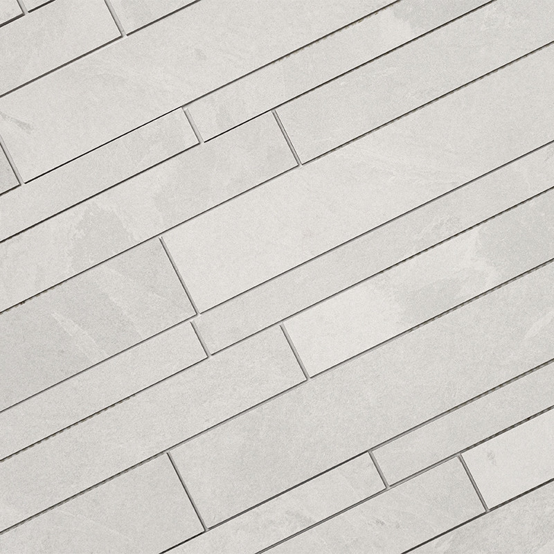 Azulejos rectangulares claros dispuestos en hileras diagonales escalonadas, juntas finas oscuras; superficie lisa con vetas sutiles, patrón repetitivo ocupando todo el plano.