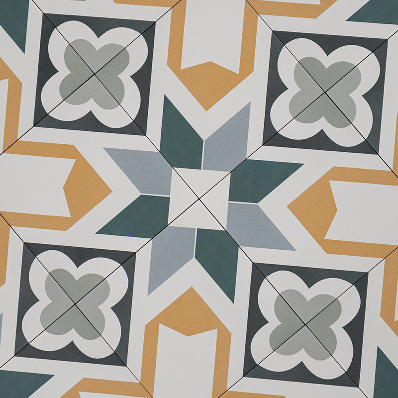 Fliese mit geometrischem Muster: zentraler achtspeichiger Stern in Blau- und Grautönen, Ecken mit vierblättrigen Ornamenten, umgeben von gelben und weißen Winkelelementen.