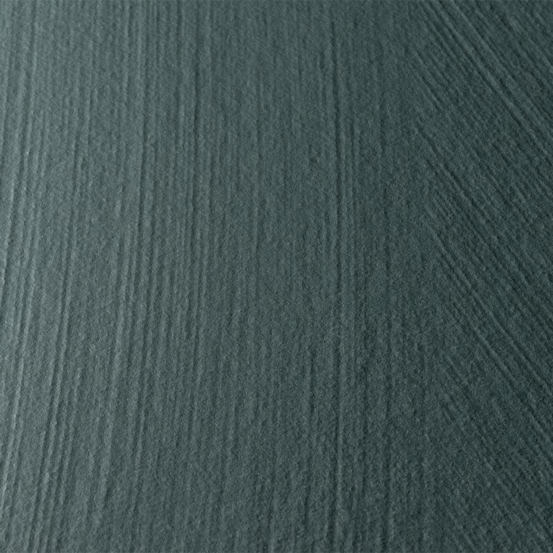 Carrelage texturé à fines stries verticales, teinte vert-bleu avec bande centrale plus sombre; surface mate en gros plan, sans éléments environnants visibles.