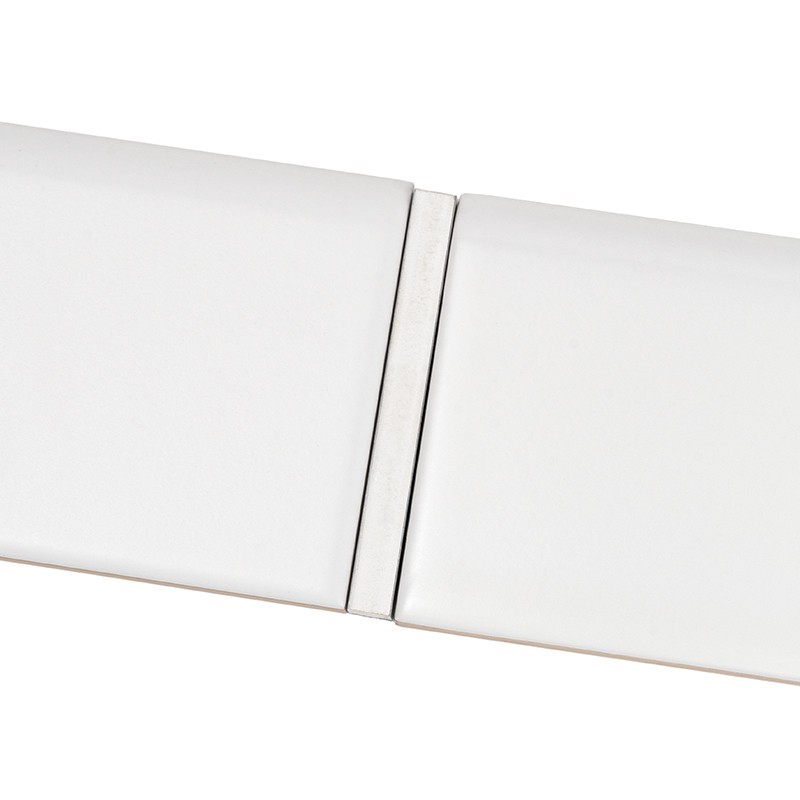 Weiße rechteckige Keramikfliesen, zwei nebeneinander mit schmaler dunkler Fuge, glatte matte Oberfläche, minimaler Schatten, neutraler heller Hintergrund.