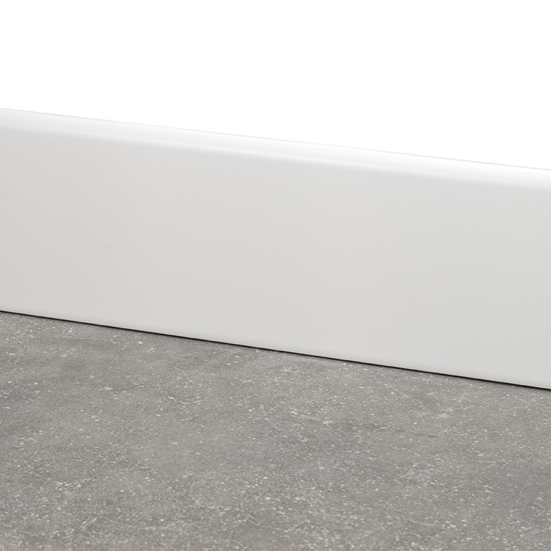Carrelage gris texturé au sol; plinthe blanche lisse posée contre un mur neutre, vue en gros plan près du sol.