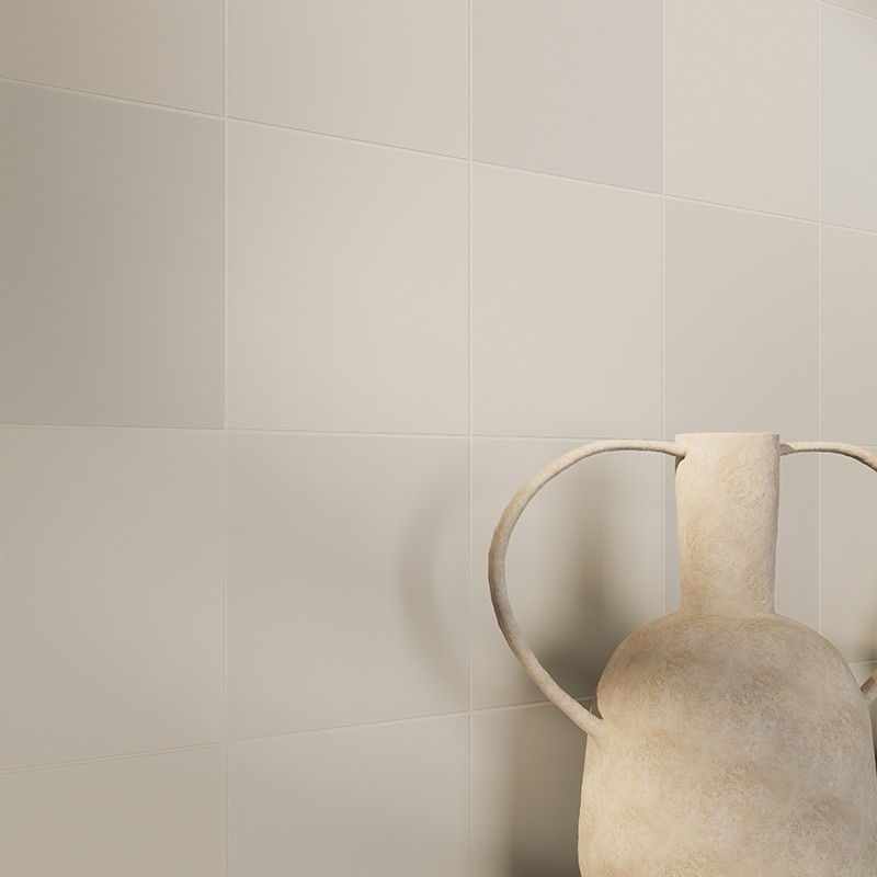 Helle, matte, quadratische Wandfliesen in sanftem Beige; rechts steht eine große, antik wirkende Tonvase mit zwei geschwungenen Henkeln.