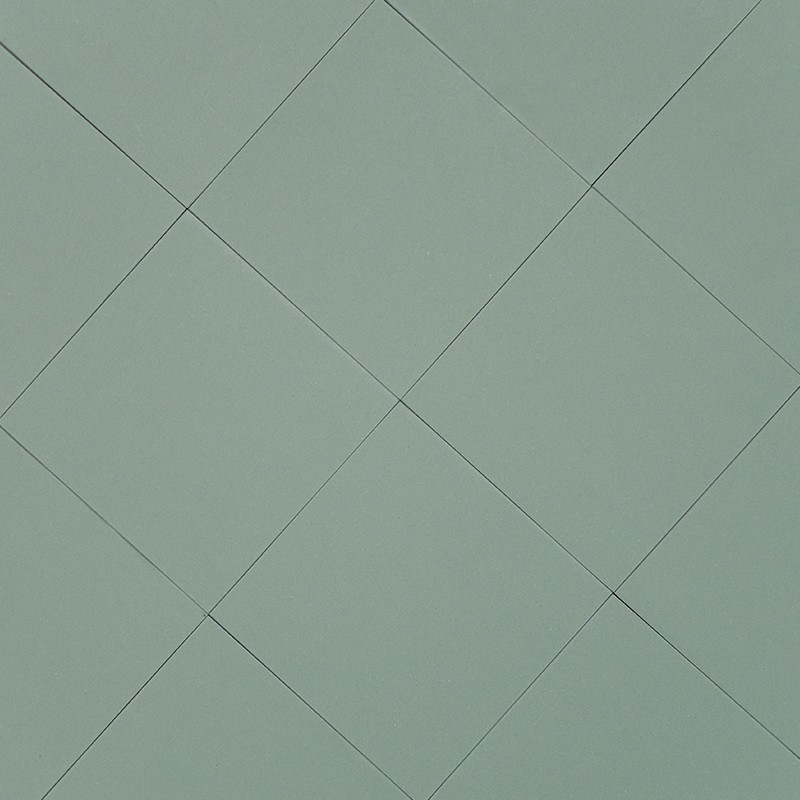 Azulejo quadrado verde-acinzentado, superfície lisa; juntas finas e escuras desenham padrão diagonal de losangos contínuos, ocupando um plano uniforme.