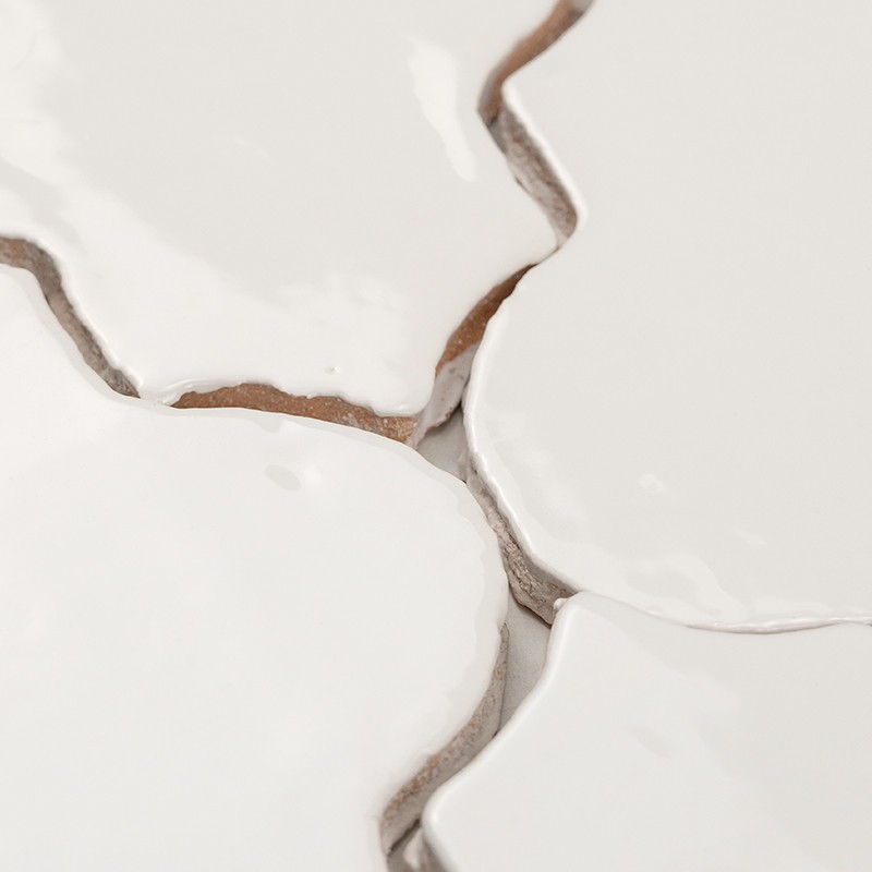 White glazed tile with curved edges; narrow joints reveal brown grout, glossy surface with reflections and adjacent arrangement forming a continuous pattern.