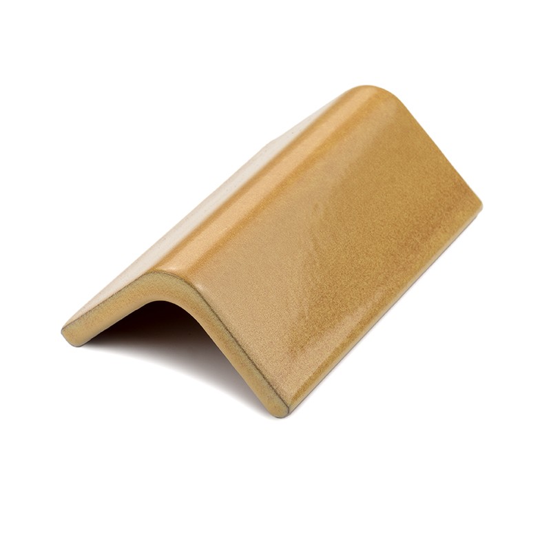 Ceramic tile, tile type, curved "V" profile with rounded corners, bright gold glaze; placed isolated on a white background, side light that accentuates its texture.