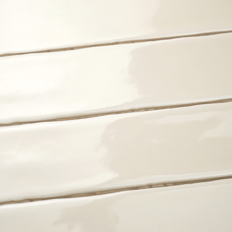 Los azulejos rectangulares brillantes están alineados horizontalmente, creando una superficie elegante y lisa. El color suave y 