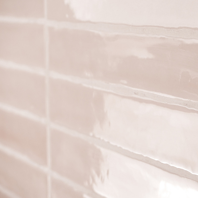Glanzende keramische tegels worden in een baksteenpatroon op een muur geplaatst, waardoor het licht zacht wordt gereflecteerd, w
