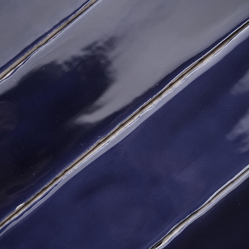 Glänzende, wellenförmige marineblaue Fliesen, die diagonal ausgerichtet sind, erzeugen eine glatte, reflektierende Oberfläche mi